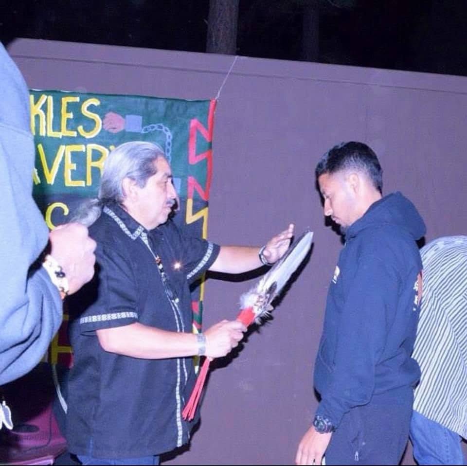 An elder blessing Alex with a feather during a Sons and Brothers ceremony